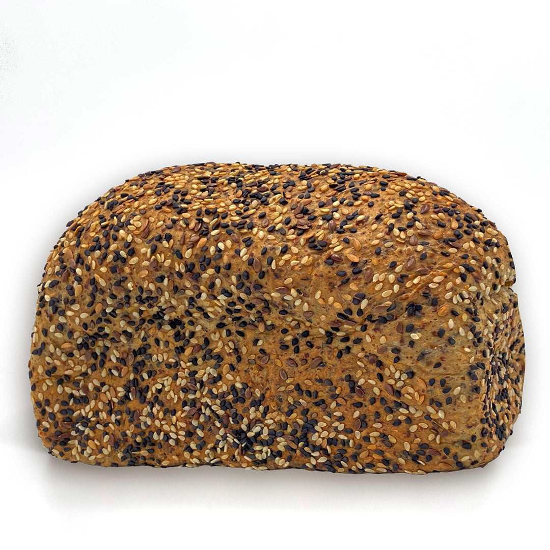 Picture - Diabetic friendly high protein seeded loaf of bread unsliced on a plain white background. 